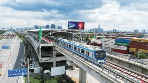 Đoàn tàu metro chạy trên cao gần khu vực Thủ Thiêm, cạnh bãi container